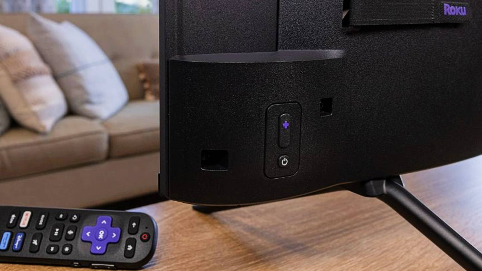 a-roku-remote-next-to-a-tv