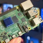 a-raspberry-pi-4-held-in-front-of-a-smart-tv